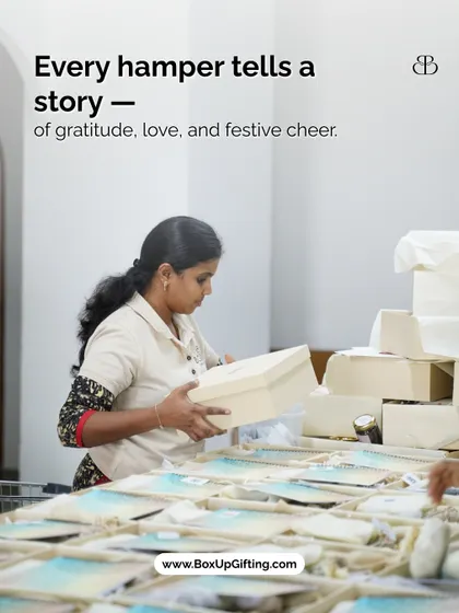 Every hamper tells a story of gratitude, love, and festive cheer. A team member carefully handles a gift box, ensuring it's perfect before it goes out.