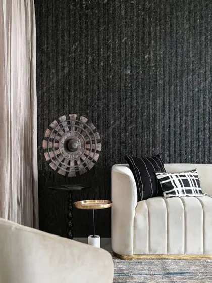 This image shows a corner of a living room where texture is the hero. The dark, grooved granite wall creates a dramatic and moody backdrop for the light-colored sofa. It’s a great example of how contrasting materials can create a powerful design statement.