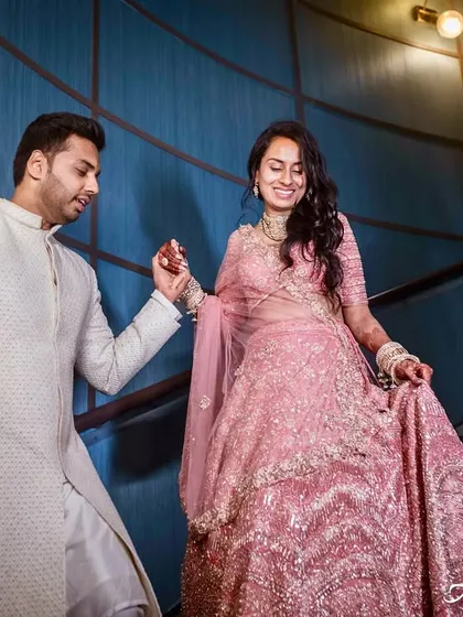 A candid shot of the couple on a staircase. The groom leads his bride, their interaction is natural and full of grace.