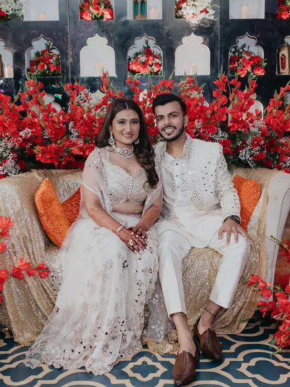 A quiet moment for the couple amidst their Sufi Night celebration. The backdrop of vibrant red flowers and ornate wall niches provided a stunning setting for their portraits.