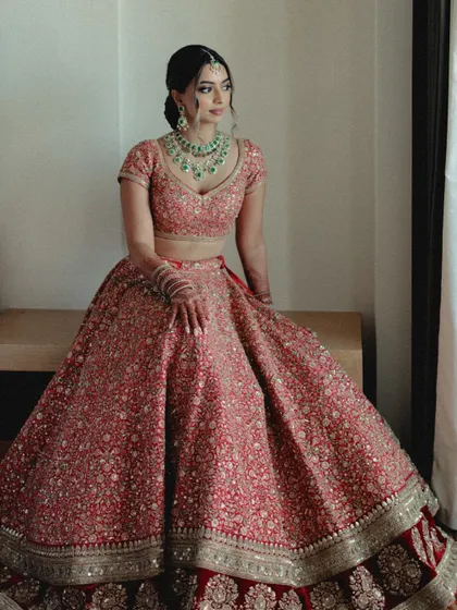 A stunning portrait of the bride in her red lehenga. Our goal is to make sure our brides feel as incredible as they look.