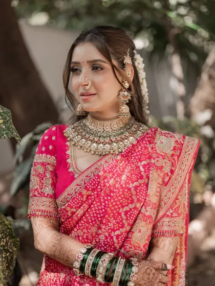 This portrait captures the soft, dewy finish of the makeup. The focus is on clean skin and letting the bride's natural beauty shine, complemented by her stunning choker necklace and traditional attire.