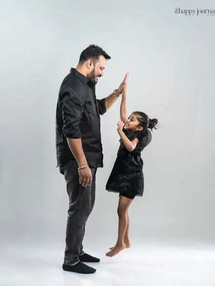 A high-five between a father and his daughter. This dynamic shot captures the fun, energy, and special connection shared between them.
