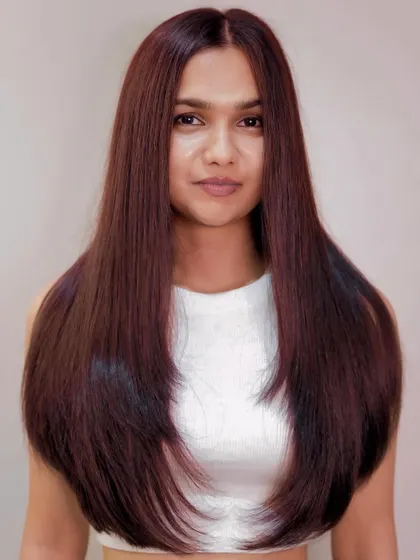 A front-on view of the long, sleek reddish-brown hair, showing off the incredible shine and precision of the color application.