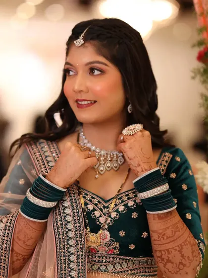 A close-up of the reception bride. Her makeup features a soft smokey eye and a warm lip color, which pairs beautifully with her teal velvet outfit.