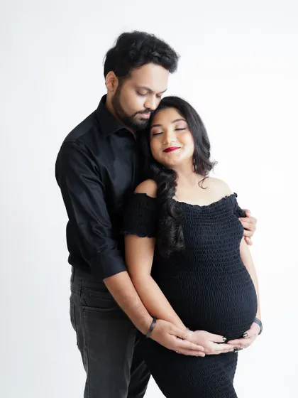 A close and intimate portrait of an expecting couple. The focus is on their gentle embrace and the peaceful expression of the mom-to-be.