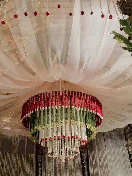 A detailed look at the multi-tiered floral chandelier, crafted with red, white, and green flowers.