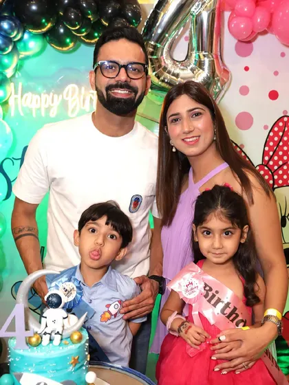 A beautiful family photo at a 4th birthday party, with a custom astronaut-themed cake.
