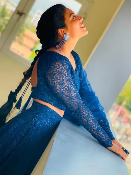 A joyful, upward-looking pose in the blue sequin lehenga, capturing a moment of happiness.