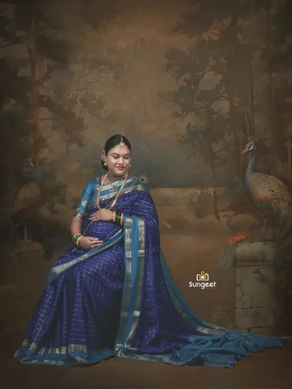 Seated against a painted backdrop of a forest with peacocks, this portrait has a classic, almost vintage painting-like quality.