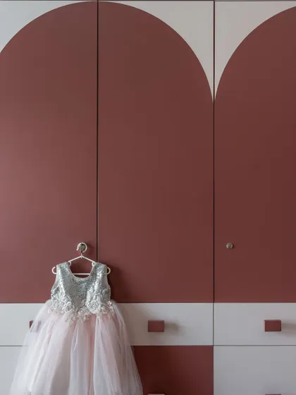 A close-up of the dual-laminate wardrobe with its unique arched design. This piece is not just for storage; it's a central feature of the room's playful aesthetic.