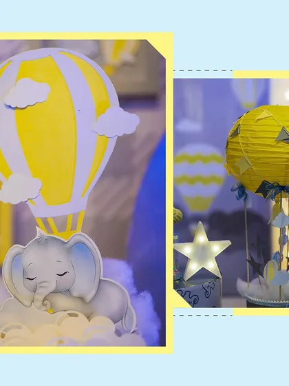 Detailed decor elements from the cute elephant and hot air balloon party. This includes a sleeping baby elephant cutout and a yellow paper lantern transformed into a hot air balloon, showing attention to every detail.