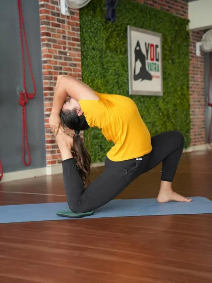 Eka Pada Rajakapotasana II, a deep backbend that combines a lunge with a quad stretch. Using a pad under the knee helps make the pose more comfortable and accessible.