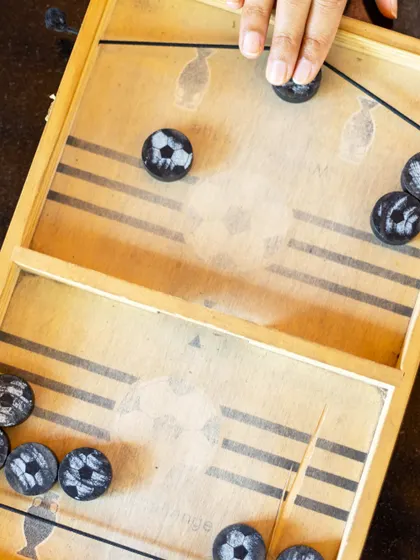 This overhead shot shows the action of a slinger puck game, a simple yet addictive game that's great for pairs.
