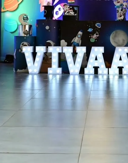 Our large, illuminated marquee letters are a fantastic addition to any theme. Here, they spell out "VIVAAN" in bright lights, adding a personalized and high-impact element to his space-themed party.