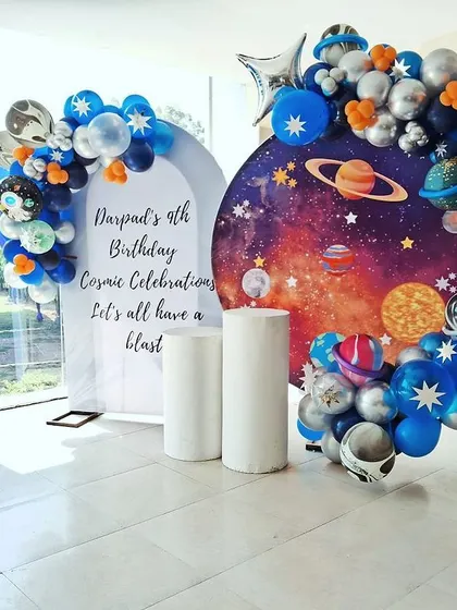 It's all in the details. For this cosmic celebration, we created a stunning photo backdrop featuring a galaxy print, planet balloons, and a personalized sign for the birthday boy's 9th birthday. It's the perfect spot for memorable party pictures.