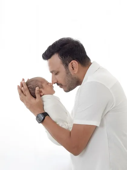 A father's gentle touch. This portrait captures the strong yet tender bond between a dad and his newborn baby.