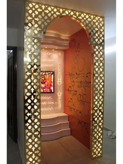 The entrance to the mandir room is framed by a beautiful arch with backlit jali work, creating a grand and welcoming feel.