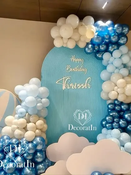 Up, up, and away. This hot air balloon themed first birthday is all about adventure in the clouds, using shades of blue and white balloons, cloud cutouts, and a custom hot air balloon prop to create a dreamy atmosphere.