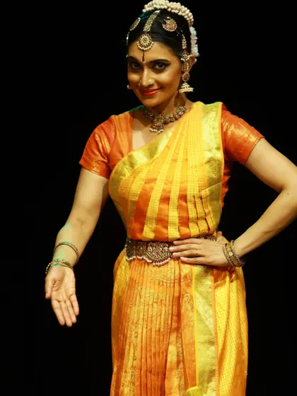 A welcoming gesture from the "SARVASYA" performance, a piece filled with divinity and joy.