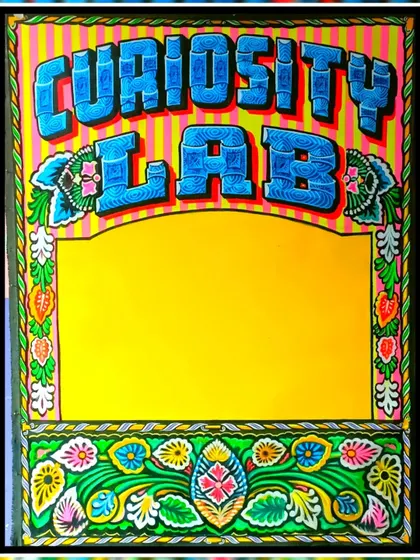 The completed sign for "Curiosity Lab," a commission for a client in the USA. The piece is framed with a vibrant, hand-painted floral border.