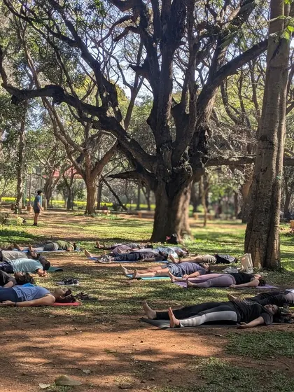 A wide view of our group in Savasana. There's a unique tranquility in surrendering to stillness together, surrounded by the gentle sounds of nature in the heart of the city.