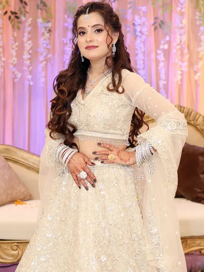 A full-length shot of the bride, looking confident and beautiful in her white engagement lehenga.