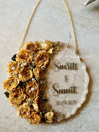 A varmala preserved in a beautiful wall hanging frame. The preserved yellow roses create a lovely crescent shape on this clear resin plaque with the couple's names and wedding date.