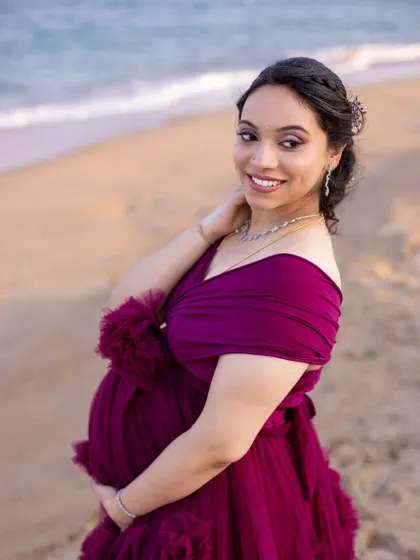 A stunning close-up portrait of the mom-to-be, her happy glow enhanced by the beautiful beach lighting and elegant styling.