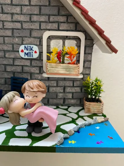 A close-up of the adorable couple miniatures from the 'Nik & Mili' nameplate. Every figure is carefully selected and placed to capture a special moment.