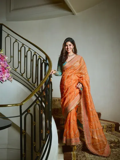 Another shot of Nimrat's elegant look on a grand staircase. The soft waves in her hair and the glowing makeup come together to create a look of pure grace for this special occasion.