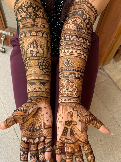 This bridal mehandi features beautiful portraits of a dancing bride and a groom. The level of detail in their outfits and expressions makes the design come alive.