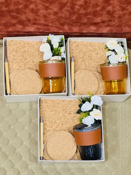 A simple yet elegant corporate gift set. These hampers feature a glass tumbler with a leather-style grip, a matching pen, and cork coasters, perfect for desk essentials.