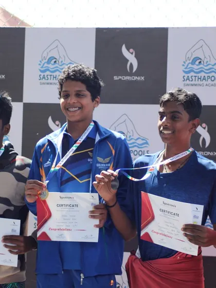 A group of smiling swimming champions after receiving their well-earned medals.