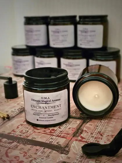 A collection of 'Enchantment' Amber Jar Candles, ready to be labeled. The amber glass gives off a particularly warm and cozy light when the candle is burning.