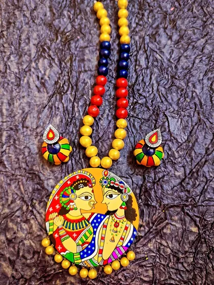 A beautiful Madhubani style Radha Krishna painting on a terracotta pendant. This is a classic, high-demand piece for festive seasons and for customers who appreciate traditional Indian art forms.