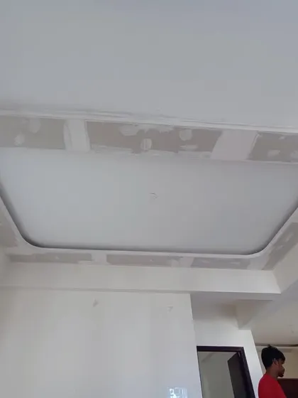 This image shows the initial stage of a false ceiling installation. Our team has created the framework and is preparing the surface for the final plastering and lighting fixtures.