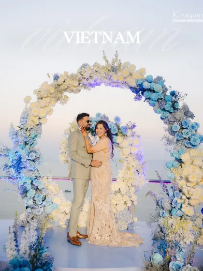 A stunning wedding setup in Vietnam, with a floral arch of blue and white hydrangeas overlooking the water. We find the most picturesque locations for your special day.