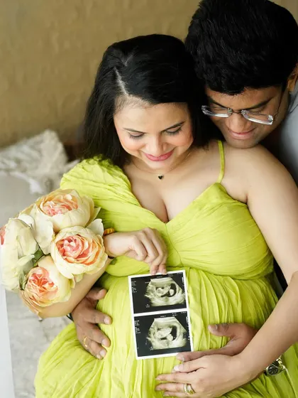 A close-up shot of the couple looking down at their sonogram pictures, their faces full of love and wonder.
