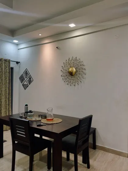 A simple yet elegant dining setup. The focus here is on clean lines and subtle decor, with a striking metallic wall art piece adding a touch of glamour.