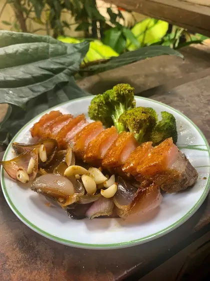 A simple, rustic plate of our crispy pork belly with sautéed shallots and garlic. This dish represents our core philosophy: honest, flavorful food made with care, just like we would at home in Coorg.