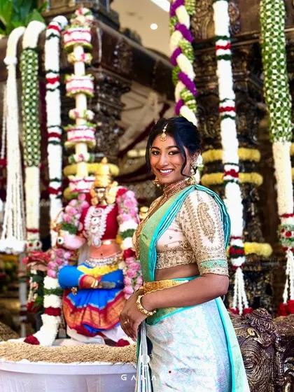 Keerthana standing before a traditional temple backdrop, her modern ensemble creating a beautiful contrast. This image perfectly captures the blend of contemporary style and cultural roots that my brand represents.