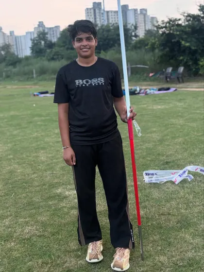 A female athlete poses with her javelin. Confidence is a key part of performance, and we build it through rigorous preparation.