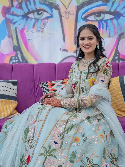 The happy bride seated against a vibrant, custom-painted backdrop that was a centerpiece of the carnival decor.