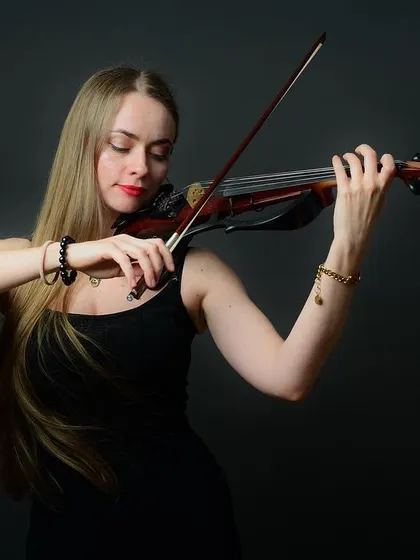 A close-up of the violinist, focusing on her technique and passion. The lighting highlights her expression and the details of the instrument.
