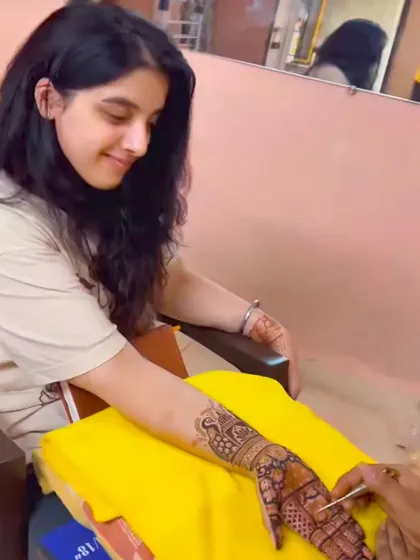 A candid moment of a client admiring her mehandi as it's being applied. We love seeing our clients happy with the process.