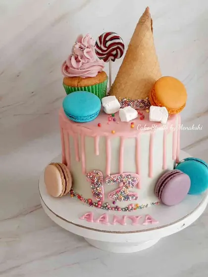 All her favorite treats for Anya turning 12. This drip cake is loaded with macarons, a cupcake, a lollipop, and an ice cream cone.