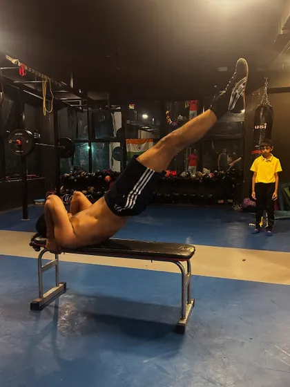 Core strength is the foundation of all power. This client is performing leg raises on a bench, an essential exercise for building the stability needed for striking and lifting.