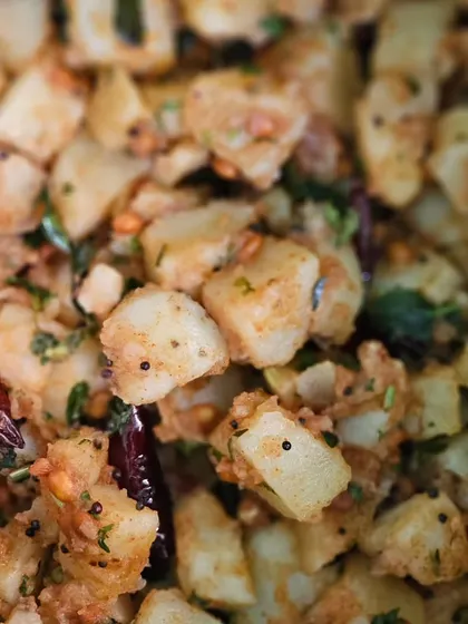 A close-up of our spicy potato fry, seasoned with mustard seeds, curry leaves, and dried red chilies.