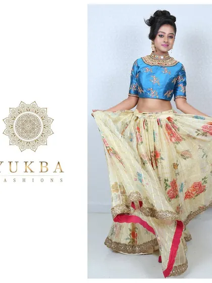A playful shot that highlights the beautiful flare of the floral organza lehenga and the intricate work on the custom-matched blue blouse.
